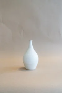 Handgemaakte Small Vase Matte White van Iris Floor Ceramics, met een smalle hoge hals en kleine flens, gepresenteerd tegen een neutrale achtergrond. Het matte witte glazuur benadrukt de slanke lijnen van de vaas.