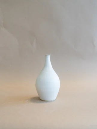 Handgemaakte Small Vase Matte White van Iris Floor Ceramics, met een smalle hoge hals en kleine flens, gepresenteerd tegen een neutrale achtergrond. Het matte witte glazuur benadrukt de slanke lijnen van de vaas.