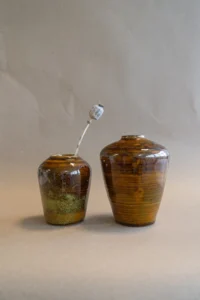 Handgemaakte Tigers Eye kleine vaas van Iris Floor Ceramics met een papaver droogbloem, met warme bruine en gouden accenten.