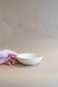 Structured Bowl schaaltje vastgehouden, met ongeglazuurde buitenkant en decoratieve carving binnenkant.